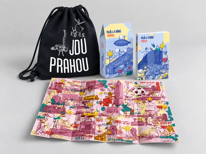 Batoh Jdu Prahou, krabička, kniha a rozložená mapa